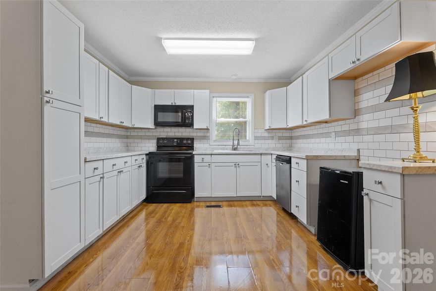 Beautiful full brick ranch featuring 3 bedrooms and thoughtfully updated throughout, making it truly move-in ready. The kitchen offers a tile backsplash, ample cabinetry, and a comfortable eating area. Interior highlights include crown molding throughout, new blinds, fresh paint, and updated lighting fixtures. Major systems have been recently replaced, including the roof, HVAC, and water heater—all within the last 5 years. A moisture barrier has been installed in the crawl space for added peace of mind. The laundry area is conveniently located in the utility room off the carport, complete with heating and air, shelving, and cabinets. Enjoy the large fenced yard, perfect for a pool, play area, or relaxing outdoors. A rare find that feels practically like new.