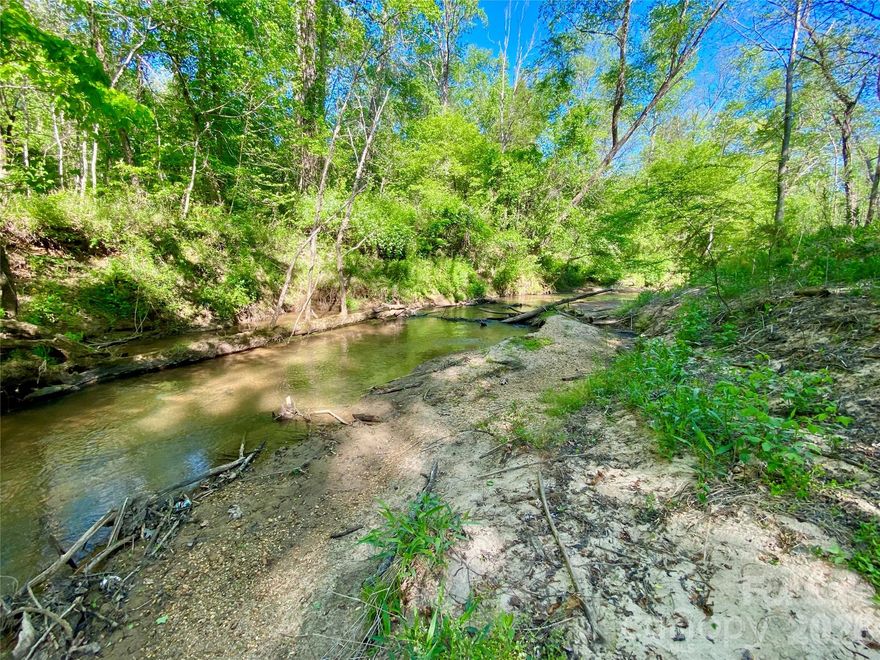 If you've been dreaming of owning your own private creekfront oasis in a small, established community with only 7 lots total in over 120 acres where you can build your dream home, then you can't afford to miss this property. At only 5.46 acres, it's situated perfectly at the end of the road along part of the cul-de-sac, with approx 600' of bold Mountain Creek frontage, with a private natural beach area with easy access to the water. A 4-bedroom septic and well permit is already approved and good through 3/2/27. Some initial clearing and grading were done to prep the homesite, but the remainder of the land is wooded and gently sloping. The homesite sits well back off the road and only the driveway is cut in to leave ultimate privacy from the private, recently paved community road. The drive in from Hwy 64/74 is absolutely goregous, crossing the community bridge over Mountain Creek and winding through tree-lined paved roads and a beautiful HOA common area pasture. This is truly a gem of a community, with its location only 5 miles/8 mins from the heart of downtown Rutherfordton but you feel like you're 30 mins from everything inside the community. Currently no mandatory HOA dues, but the HOA is in the process of establishing officers of the board and regular meetings moving forward. The listing agent is the owner of this property, so feel free to ask any questions you may have.