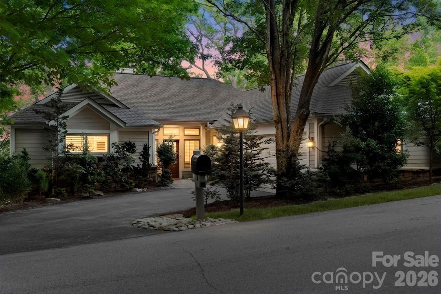 Set within Champion Hills, 8 Spring Ridge Lane offers a front-row seat to one of the area’s most established private communities. Positioned along a gentle ridge, the home takes full advantage of its northeastern exposure, with long-range mountain views that unfold gradually with the morning light.

The setting is just as compelling up close. Mature, thoughtfully designed landscaping surrounds the home, creating a natural sense of privacy while framing mountain views in nearly every direction. It’s the kind of setting that feels settled—nothing forced, nothing out of place.

Inside, the main living area is centered around those views, with large windows and an easy, open flow that keeps the landscape in focus. Granite countertops, hardwood floors, and well-executed custom closets speak to the quality of the home, while radiant heated floors in the bathrooms add a quiet level of everyday comfort. The layout is well balanced, with a main-level primary suite and inviting guest spaces below—comfortable for daily living and easy when hosting.

The connection to the outdoors is carried throughout. An upper back deck with a retractable sunshade offers a comfortable place to take in the mountain air, while the screened-in porch provides a quieter, more sheltered setting with the same long-range backdrop. Below, a private lower deck creates another vantage point, along with a tucked-away hot tub that feels completely removed—an easy place to end the day.

This home has been meticulously maintained, and it shows in the details. For those seeking a more immediate transition, there is also an opportunity to purchase the home fully furnished with a curated selection of high-end furnishings, including housewares and outdoor pieces, available separately.

Life in Champion Hills moves at its own pace. The Tom Fazio-designed course is a constant presence, along with a clubhouse that serves as a natural gathering place for dining and social events throughout the year. Fitness, tennis, pickleball, and walking trails are all part of the routine here, naturally woven into daily life.

Despite the setting, you’re only minutes from downtown Hendersonville, making it easy to step in and out of town as needed.

At 8 Spring Ridge Lane, the views, the setting, and the level of care throughout the home come together in a way that feels established and enduring—exactly what draws people to Champion Hills in the first place.
