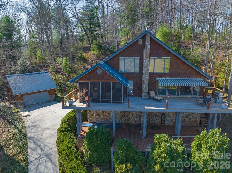 Welcome to this stunning 3-bedroom, 2.5-bath mountain home with stunning views of Graham and Swain Counties. Built with quality and efficiency in mind, it offers low utility costs and timeless finishes, including wormy maple wood, tongue-and-groove ceilings sourced from the property, and Brazilian mahogany floors. The kitchen features custom cabinetry, granite countertops, and a Bosch oven, while the living area includes a gas fireplace and a hidden wood-burning fireplace. Enjoy year-round comfort with central HVAC and high-speed Starlink internet. Relax on the expansive deck with screened and open-air spaces, plus a motorized awning for added comfort. The walk-out basement includes a large workshop, storage, and a secure vault room. A separate 2-car outbuilding with independent metering offers flexible use as a garage, studio, or rental. Short-term rentals are allowed, and you're just minutes from Tail of the Dragon—making this the perfect blend of adventure and mountain living.