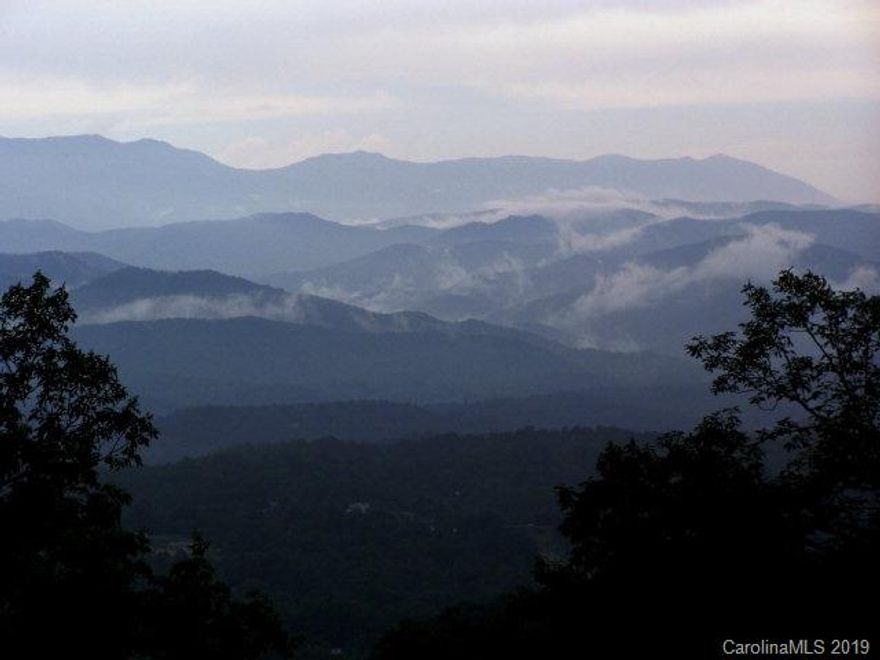 LOOK AT THIS PRICE! There is probably not a better value anywhere ... Absolutely stunning views are available from this northside ridgetop lot in gated, paved Grants Mountain. View photos are from next door neighbor's home, but this could be your view too--from Mt. Mitchell to Grandfather's Mountain and beyond--with clearing of your view corridor. Level building spot, easy, level driveway, and WELL is in. This lot is one of the largest in the subdivision, and has another lower spot on which to to make a totally private in-the-woods haven. (see contour map). Easy access and priced WAY below cost. Grants Mountain is a lovely mountaintop community with underground utilities, great neighbors and unparalleled views from all around the mountain. Hurry - will not last long at this price.