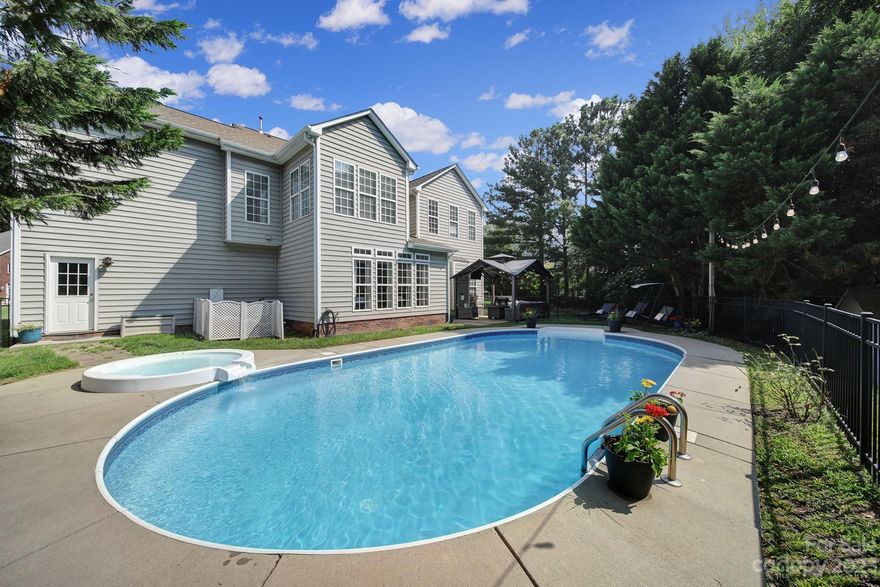 Welcome home to your oasis in Fort Mill. This home boasts square footage as well as a backyard made for entertaining w/ an in-ground heated pool & hot tub & large patio area. As soon as you step through the front door, you'll be enamored w/ a tranquil feeling as you gaze through the main level finding the formal dining room, an office w/ french doors, & a very cozy living room with coffered ceiling & gas fireplace. The large, open kitchen has plenty of storage & room to cook and hang out with an oversized island & brand new Silestone countertops. Notice the fresh modern feel from the brand new LVP floors, new carpet upstairs, & new paint throughout the entire home as the natural light pours in. Head up the grand staircase to find all of the bedrooms, including the primary suite, and the laundry room. You'll also be impressed by the large bonus room for even more living space. Just beyond the back fence of the pool area, you'll also find a playset for the kids & shed for yard tools.