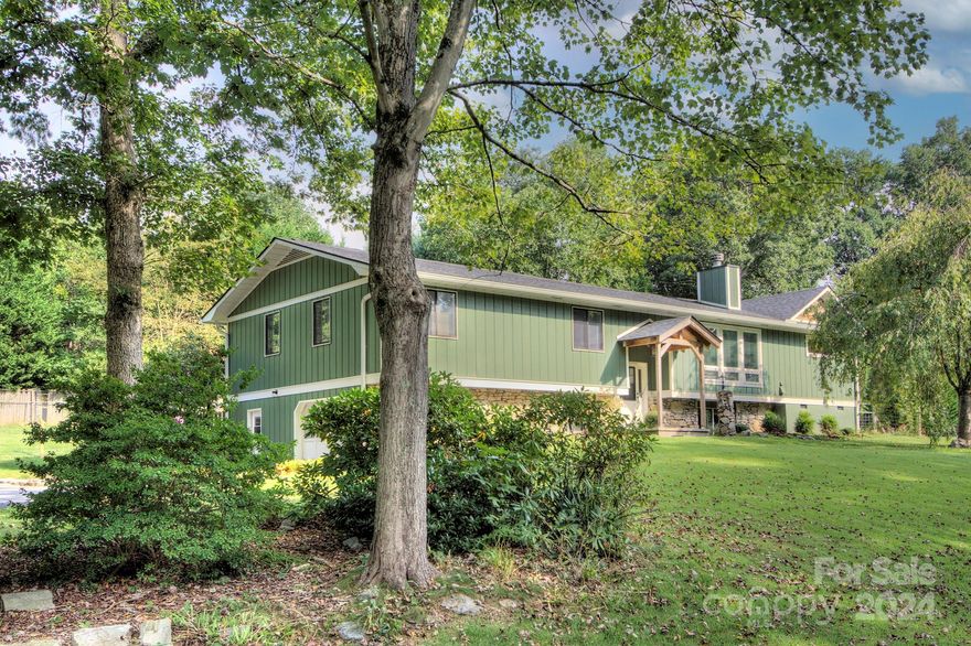Beautifully renovated four-bedroom home in Fletcher Hills! Highlights include an open floor plan with vaulted ceilings, marble countertops in the kitchen and primary bath, stainless steel appliances, hardwood & tile floors, natural gas tankless water heater and stone fireplace. Enjoy morning coffee on the screened back porch overlooking the fenced backyard. The primary bath showcases a dramatic soaking tub, double vanities, two walk-in closets and a tile shower.  The living room fireplace insert has a blower and ductwork that provides heat to the lower level. Downstairs, you will find a large media room with half bath, perfect for hosting your next football party. The oversized single garage has plenty of workshop space for the hobbyist. Great walking neighborhood with mature trees, flat streets and no HOA. Convenient location minutes from the Asheville airport, shopping and restaurants!