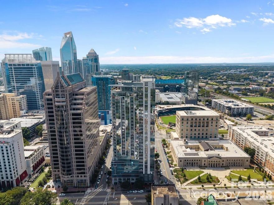 THE TRADEMARK @ 333 W. Trade Street isn’t just an address: it’s a LIFESTYLE.
In the heart of Uptown Charlotte, the iconic Trademark is steps from all the City has waiting! Enter UNIT #1202: This 2BR/2BA overlooks Uptown and Trade Street with a RARE STORAGE UNIT in the basement level of the building! Appointed kitchen w/granite, custom cabinets, large island & glass backsplash. SS oven/fridge/DW new in ‘23. Eucalyptus wood floor combines beauty w/durability in main living area. MBR w/ interior windows for a modern feel, bath w/step in shower, framed mirror and walk-in closet. 2nd BR has en-suite with shower/tub combo, framed mirror. Sleek ELECTRIC FIREPLACE for those chilly evenings or ambiance when you want it! Dining rm highlighted w/crystal chandelier. HVAC ‘25, water heater ‘24. Resort amenities: rooftop pool/sun deck with Charlotte skyline views, gas grills, clubhouse/ex room, gated parking.  Amazon hub, EV stations, steps from BofA, Truist Field, light rail and fantastic dining!