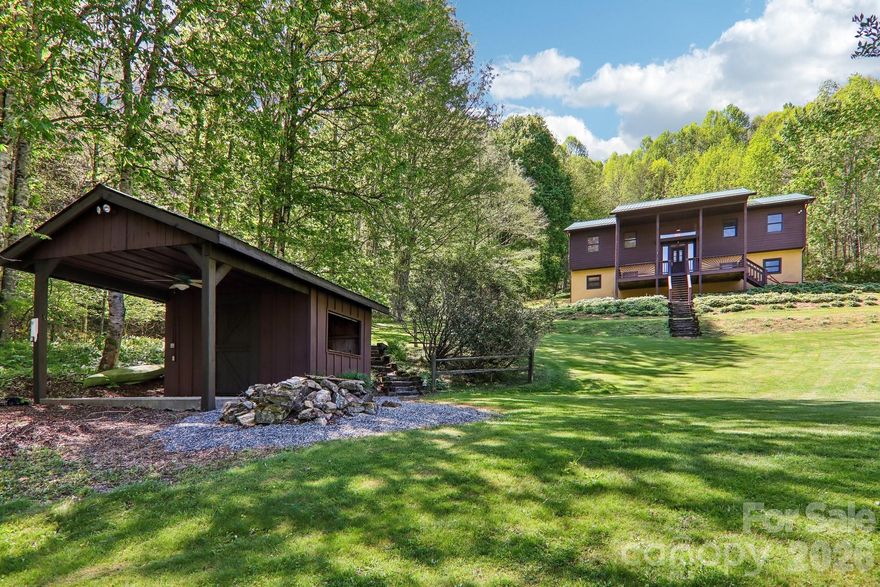 Custom built 2300sqft home on 2 levels in private location with 5.60 acres with double garage in basement with new garage doors. Wood floors have just been redone. Open floor plan with kitchen that offers an island, wormy chestnut cabinets, stainless appliances. 2 Primary suites on main level, one offers jacuzzi soaking tub, separate shower and double sinks and access to back 373sqft deck. Lower level open with tiled floors, 1/2 bath and wet bar. New roof in 2026, new heating/cooling system 2026, skylights w/auto blinds. exterior paint 2026. Outbuilding with covered porch for grill, small pond. MUST SEE THIS WELL-MAINTAINED HOME AND LOCATION!! French Broad Fiber available. Minutes to Hatley Pointe ski and mountain bike, restaurant area, minutes to Wolf Laurel Resort Golfing and fitness center. Easy 15-minute drive to I26 corridor access.