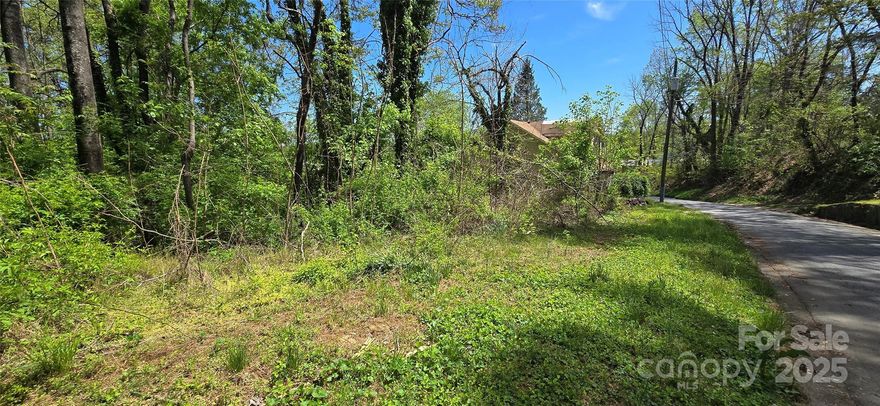 Partially cleared sloped lot with city water and sewer. Zoned R-6 permitting manfactured doublewide, stick built, multifamily (duplex or triplex). Two additional lots available adjacent. Cleared/wooded acreage is approximate. Setbacks are 35 feet from road, 10 feet from each side boundary, and 25 feet from rear boundary.