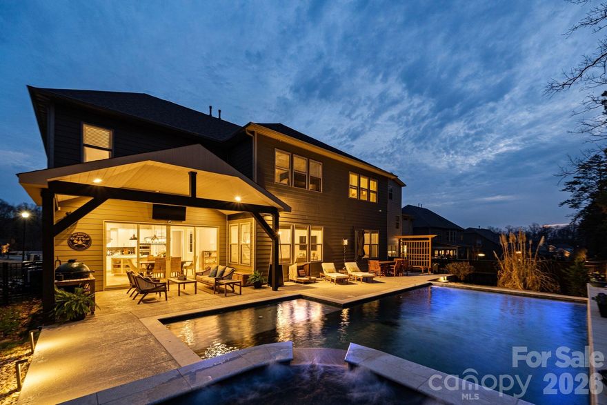 Welcome to a home where design, privacy, and lifestyle come together seamlessly. From the moment you step outside, it’s clear this property was built to impress. The stunning resort-style backyard feels like a private retreat - complete with a heated custom pool and spa, expansive patio space, and a vaulted covered lounge designed for year-round enjoyment. Whether you’re relaxing in the hot tub, grilling with friends, or enjoying a quiet evening by the water, every detail was intentionally crafted. With mature trees behind the property and no rear neighbors, the setting offers rare privacy and a true sense of escape!

Inside, the upgrades continue at every turn. A custom sliding door frames expansive pool views from the kitchen, creating effortless indoor-outdoor flow that anchors the home’s ideal layout for entertaining. The kitchen is complemented by a butler’s pantry with beverage fridge, designer lighting, elevated trim work, and high-end finishes throughout. Eight-inch wood flooring runs through the main living areas, while custom accent walls add warmth and character.

Multiple office and flex spaces allow the home to adapt to your needs - whether that means working remotely, creating a fitness room, or designing a quiet reading retreat. A spacious mud room and large storage area add everyday functionality without sacrificing style. Upstairs, a fully soundproofed bonus room creates the ultimate setting for movie nights, gaming, or immersive entertainment.

The garage delivers something truly special - epoxy-coated floors and a 9,000-pound car lift combine to create the ultimate car enthusiast’s dream space!

As the sun sets, low-voltage exterior lighting surrounds the home and casts a warm architectural glow across the fenced backyard oasis, elevating both curb appeal and evening ambiance.

This is a floor plan designed to breathe - open enough to host effortlessly, yet comfortable enough for quiet nights at home. All of it set in a prime location just minutes from Indian Land’s exciting growth, popular restaurants, everyday conveniences, Target, Costco, and more.

Resort-style living. Everyday privacy. Space to entertain, unwind, and truly enjoy where you live!

*1% Lender Credit when using preferred lender!*