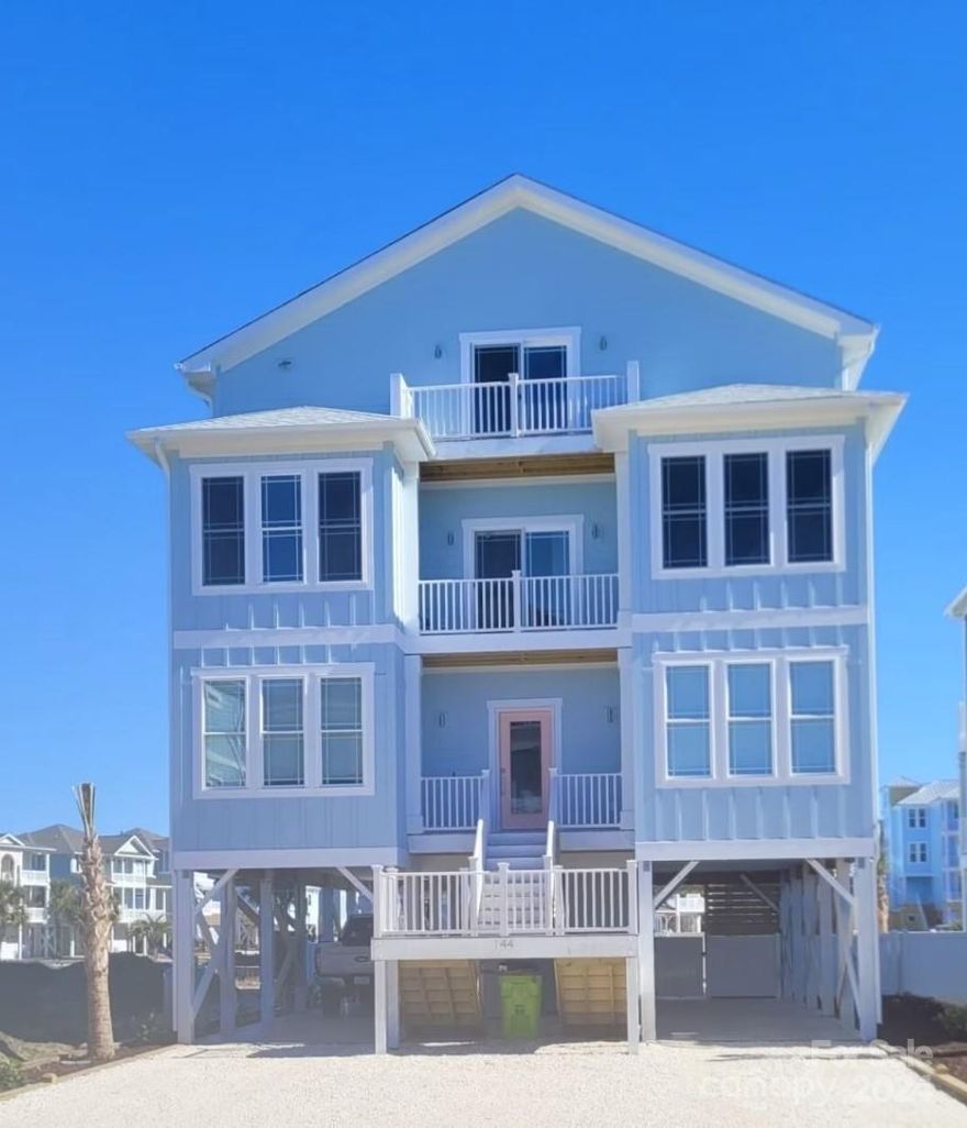 Investment Opportunity!!  Proven 6 figure rental history for 2023, and 2024 Summer season fully rented.  Gorgeous ocean & lagoon views from back of home & covered porch/decks. Large beachhouse, 4,200 GLA, with 8 Bdrms,8 1/2 baths, large Theater room with custom theater chairs, overhead projector & appx. 150" screen for movie nights & gaming, also large game room on third floor with queen bed. Private In-Ground, heated 14' x 32' pool with Tiki wet bar & TV.  Master bath on first floor has double rainfall 5' shower.  Master Tower bedroom has 12' ceilings with electric fireplace & private balcony. Elevator services all four levels of home. 2 tankless gas hot water heaters.  Open kitchen has large island with bar seating, gourmet gas cooktop, walk in pantry, open to G/R which has coiffured ceilings & gas log fireplace. Opportunity to join the Isle Beach Club Community Oceanfront pool. Short walk to beach. Yard landscaping with palms, rear fence enclosing pool, & white Bahama rock driveway.