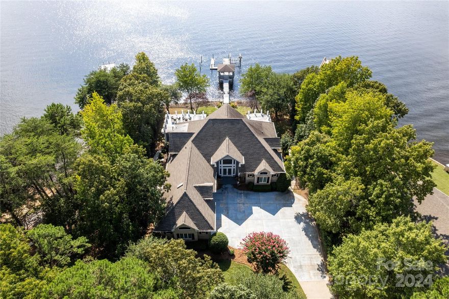 Spectacular Main Channel Sunset Views Over Little Mountain from this Custom Home on Private Point Lot! 4 Bedrooms, 4/2 Baths, All formals, Chef's Kitchen, Theater, Two Offices & lots of storage! As you make your way down the long private driveway, you arrive with gorgeous water views to the full brick majestic home. You are greeted in the entry hall with a two-story long-range view of Lake Norman. Formal dining & living as you move towards the lake. The Chef's Kitchen on your left is open to the breakfast area & generous sunroom which includes a fun cocktail bar. Behind the kitchen is a large pantry & laundry room with half bath. As you walk into the Primary Suite on the main level, beautiful lake views abound from the extended sitting area with fireplace & outdoor covered patio. You will be pleasantly surprised with the large closet & private office flanking the hallway to the primary bath. This is lake living at its finest! SELLER FINANCING AVAILABLE at 5% for qualified buyers!