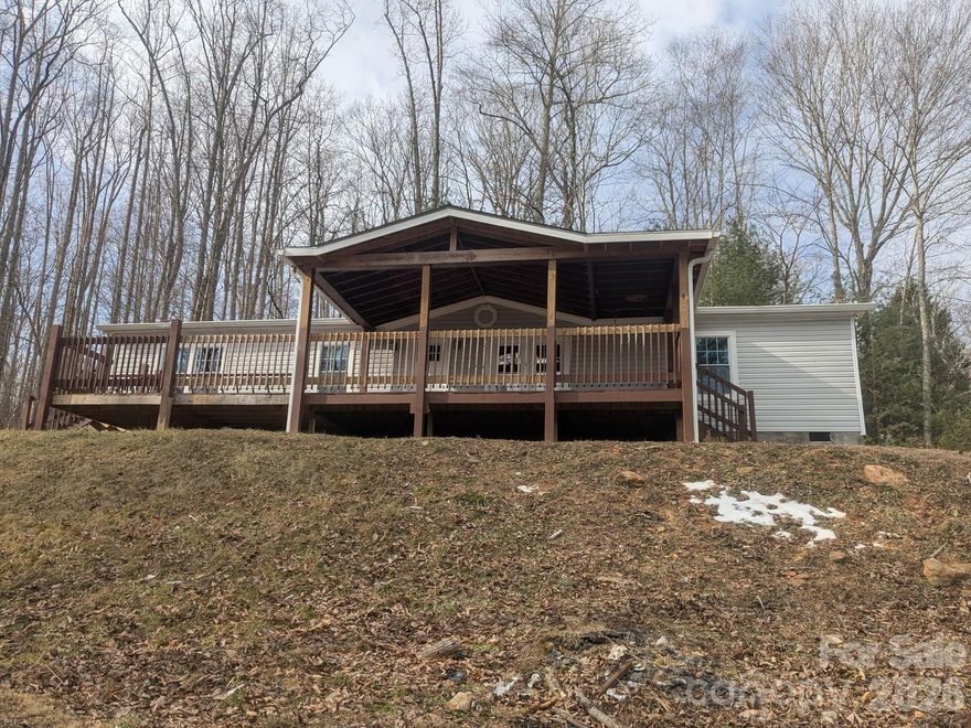Attention! This 3-bedroom, 2-bath, 1,568 HLA 1994 single-story manufactured home sits on a peaceful .55-acre hilltop lot with scenic views in sought-after Candler, located in a quiet neighborhood just minutes to West Asheville, downtown, and easy interstate access. The well-maintained home features a solid masonry foundation, no association, and recent upgrades including a 10-year-old roof, updated kitchen with granite countertops and center island, and renovated bathrooms. Enjoy relaxing mountain breezes from the front deck, with potential to clear trees for even better views. Ideal for comfortable living or as a rental investment opportunity in a prime mountain setting.