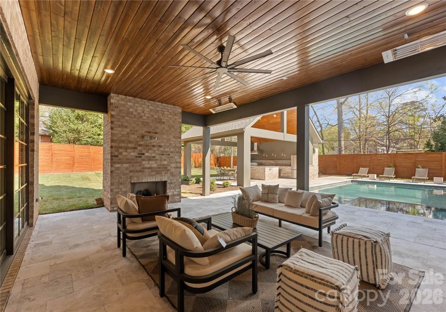 Welcome to 154 N Canterbury Rd, a showstopping luxury estate by Maverick Building that seamlessly blends elevated design, thoughtful functionality, and resort-style living in the heart of Cotswold. This exceptional 6 bedroom, 7.5 bath new construction home was designed for both everyday comfort and unforgettable entertaining. The outdoor living experience is truly unmatched, featuring a stunning pool and hot tub, a fully equipped pool cabana with a kitchen and oversized island, a full outdoor bath with changing area, and an outdoor shower. Three covered porches surround the pool, creating a private oasis complemented by expansive yard space ideal for recreation or relaxation surrounding the outdoor living spaces. Inside, the home continues to impress with curated designer finishes and refined architectural details throughout. The grand living room showcases 11-foot ceilings with exposed wood beams and a striking cast stone fireplace, while the walk-in wine room is complete with a steel frame entry door and custom cabinetry which provides a sophisticated focal point for entertaining. The primary suite is a true retreat, designed to feel like a luxury resort. Enjoy a private covered terrace looking at the pool, a spacious sitting area, and a custom coffee and wine bar. This primary suite also features a large walk-in shower, a soaking tub and an extraordinary custom closet with inset lighting, glass front cabinetry, soft close drawers, and a Taj Mahal quartzite waterfall island. A junior primary suite on the main level offers the perfect private space for guests, complete with a soaking tub and dual vanities. Upstairs, the bonus room provides incredible flexibility with built in seating, a large open layout, wet bar, and full bath that makes it ideal for a media room, lounge, or guest retreat. Every inch of this home reflects intentional design. The lighting, custom cabinetry, flooring, color palette, and wallpaper selections creating a cohesive and elevated aesthetic throughout. Situated on one of Cotswold’s most sought after and walkable streets, surrounded by high-end new construction and estate homes, this prime location offers convenient access to SouthPark, Uptown, private schools, shopping, dining, and everything that makes this area so desirable.