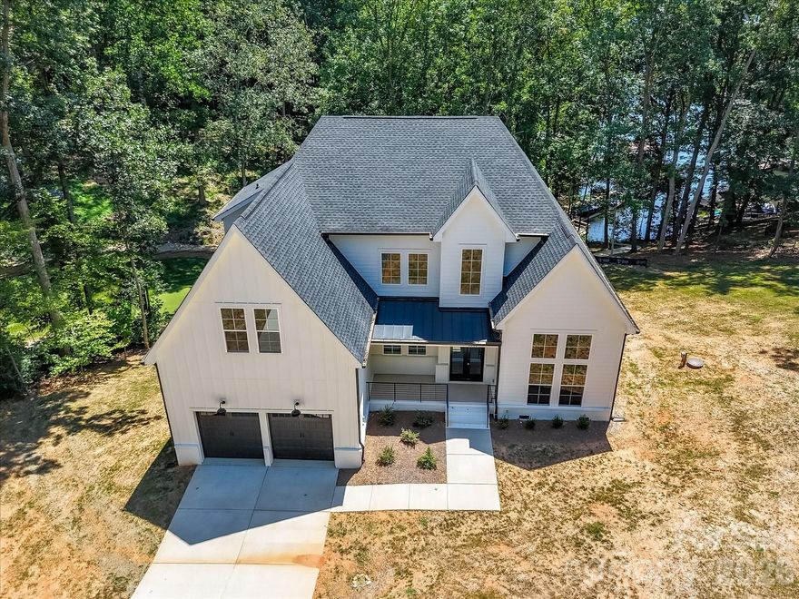 Custom, New Construction, Waterfront home situated on nearly an acre in an established neighborhood, on coveted Lake Norman! Nestled on a lush, private lot with rip rap shoreline, this property offers a peaceful cove setting with convenient access to the main channel. Thoughtfully designed with custom finishes throughout, the home blends elegance and comfort while showcasing beautiful lake views from the grand entry with soaring ceilings. The gourmet kitchen features quartz countertops, an oversized island, stainless steel appliances, pot filler, tile backsplash, custom lighting, a walk-in pantry with built-in shelving, and a bright breakfast area. A formal dining room and impressive great room highlight dramatic two-story ceilings, creating an inviting space for entertaining. The main-level owner’s retreat includes a luxurious private bath, expansive walk-in closet with custom shelving, and access to a spacious covered deck—perfect for enjoying peaceful lake sunsets. The upper level offers three additional bedrooms, including a generously sized fourth bedroom that can also function as a bonus room or additional living space. An expansive covered deck provides the ideal setting to relax and take in the natural beauty and tranquility of this exceptional lakefront property.