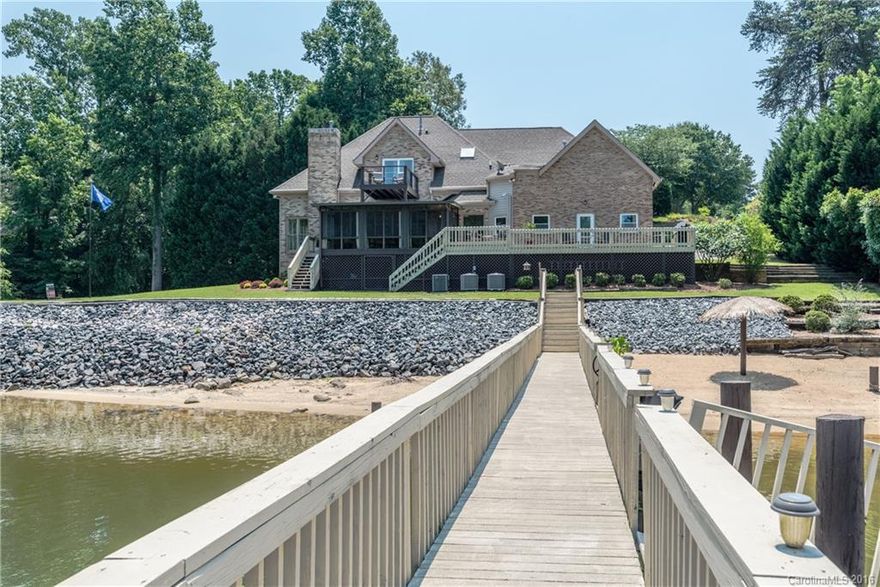 This fantastic lake house is wonderful both inside and out. With over 295 feet of shoreline, sandy beach area, pier with sitting area, boat lift, jet ski lift, and a concrete boat ramp. The interior features a brand new chefs kitchen, custom cabinets, granite counter tops, and high end appliances. Master bedroom suites on lower and upper levels. Newly finished hardwood floors. Living room with panoramic views of lake. A sunroom, decks, and second level balcony make this a lakeside paradise.