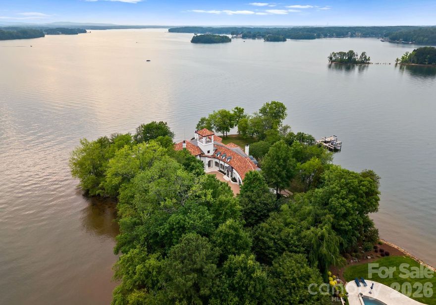 Welcome to Puesta del Sol... A Rare Waterfront Sanctuary with 938’ of Pristine Shoreline on Lake Norman — where ELEGANCE meets EXCLUSIVITY. Nestled on a private gated peninsula, this estate offers 938 feet of shoreline & panoramic lake views from every level & bedroom! Inside, light-filled spaces, curved walls, designer finishes, & a gourmet kitchen set the tone for effortless luxury. The main-level primary suite offers luxurious bedroom, dual closets, and separate shower 7 spa-like bath. Take the elevator to the second level boasting 2nd primary suite plus 3 additional spacious en-suite bedrooms, theater, billiard room, and exercise space. End or begin the day on the rooftop covered terrace with stunning sunrise & sunset vistas. The outdoor spaces are equally impressive: pool and spa, private pier with a dock, boat lift equipped with electric Swiftshield cover & jet ski lifts. This is more than a home — it’s a rare lifestyle opportunity on one of North Carolina’s most desirable lakes.