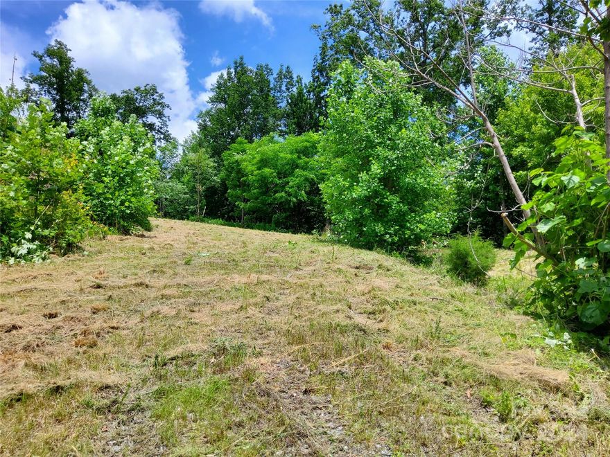 IDEAL HOMESITE IN GATED MOUNTAIN COMMUNITY.  Lot is located in the gorgeous community called The Highlands of Lake Lure.  Lot 14 sits high enough to have long range views of Lake Lure & surrounding area.  Buildable footprint is on smaller size & would best accommodate a 2-story home such as a chalet & will offer panoramic views with select tree cutting.  Being a corner lot, access the proposed building area by walking down the gravel road to cleared area.  Owner has a legal Easement to use gravel road for ingress & egress.  This lot abuts to a 30+ acreage which is privately owned, protecting the privacy & seclusion of Lot 14.   Close to all outdoor fun & activities like golfing, swimming, boating, horse-back riding, zip lining, hiking, antique shopping, restaurants & so much more.  Terrific opportunity to buy a lot at a great price in the breathtaking western North Carolina mountains.  Owners are MOTIVATED TO SELL.   No damage from hurricane Helene at this location. Views--Views--Views