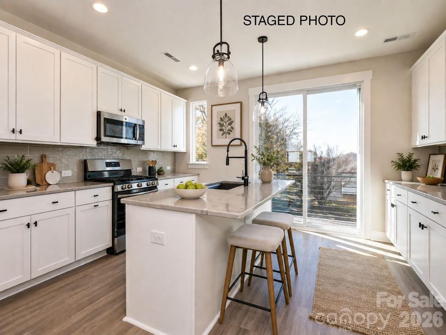 Have it all with this Camp North End-area townhome. 4 floors include a 1st floor flex room w/ powder, terrace off the kitchen w/ seasonal city skyline views, & a nice sized 4th floor rooftop terrace & bedroom/rec room w/ powder. Abundant space for entertaining, guests, or home office. Also included is a 1-car garage & driveway.  Kitchen features 42" cabs, matte black hardware, trash pullout, large undermount stainless sink, quartz counters, and GE stainless steel appliances with a gas range. It leads to the open dining/living area. 3rd floor has a laundry closet and a hall bath. Full baths include matte black hardware, quartz counters, and tiled floors, with a tiled shower in the Premier Bath with semi-frameless glass. LVP is throughout the 1st & 2nd floor plus 3rd floor hall, with tile in full and half baths, and oak treads on all stairs. 9' ceilings throughout. Uptown Charlotte is just minutes away!