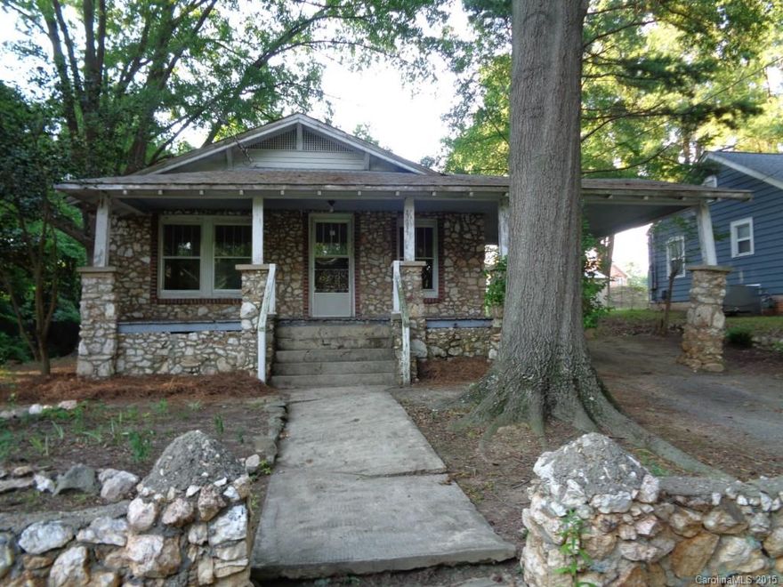Rock house with two fullbath at end of street with carport and large front porch