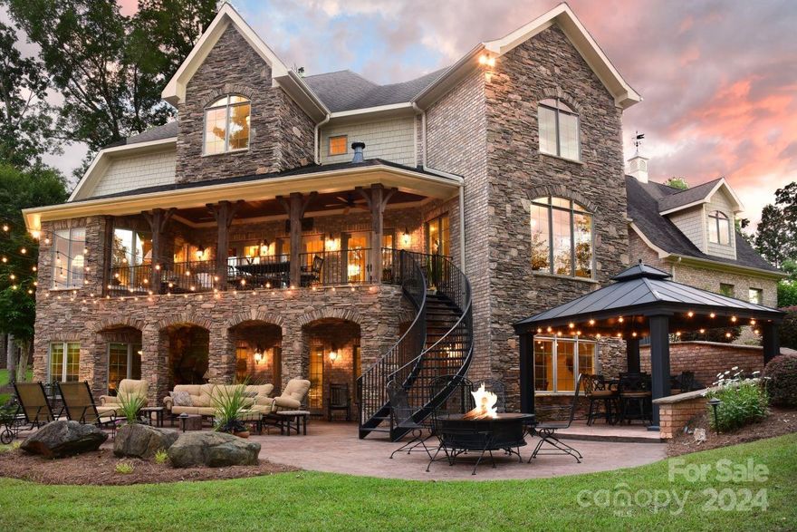 One of a kind, luxurious waterfront home! Custom built with unsurpassed quality. Deep water & large two slip boathouse with storage area. This exquisite home has a wonderful floor plan with a 2 story great room & one of a kind fireplace! 5 bedrooms, 4 full bathrooms & 2 half bathrooms! Gourmet kitchen is covered with upscale cabinetry & high end granite with a lot of glass overlooking the lake. The covered porch just off the great room has a stone floor with amazing cedar beams looking out to the water. Primary suite located on main floor with breathtaking water view, vaulted ceilings, large primary bath with shower, tub, & walk in closet! Den in basement has wet bar & wine fridge & gives easy access to covered gazebo & grilling station. Beautiful covered patio w/rock columns & large open patio. 2-slip boathouse has bar area w/cabinetry & granite countertops!