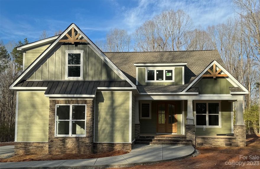 This semi custom-built home offers a blend of modern luxury and natural beauty all within a private setting surrounded by 2.235 acres of wooded landscapes. With 4 bedrooms plus a versatile bed/bonus room, this home offers ample space for a growing family, guests, or a dedicated home office. A primary suite on the main level ensures convenience and privacy. Three full baths offer comfort and convenience for everyone. Inside, an open-concept floor plan adorned with luxury vinyl plank flooring creates a seamless flow between spaces that feature vaulted ceilings, stone fireplace, chef-inspired kitchen with a spacious island, granite countertops, custom exhaust hood, and top-of-the-line appliances. Outside a covered back porch featuring EZ Breeze windows allows you to enjoy the surrounding beauty in any weather. An adjacent grilling patio offers the perfect spot for outdoor dining and entertaining. Add’l perks include laundry room with built-in shelving and ample storage space.