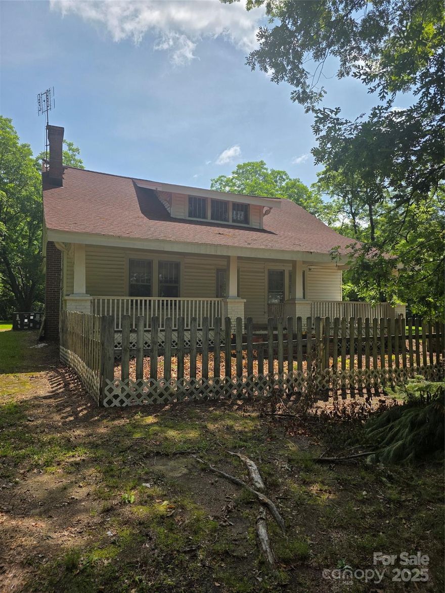 Nestled on 2.82 secluded acres dotted with mature trees, this historic circa-1900 single-story residence offers around 1,700?sq?ft of classic charm. Inside, soaring 10–11-foot ceilings frame spacious rooms filled with hardwood floors, a large living room with closed up fireplace, formal dining room, and kitchen equipped with a stove and dishwasher. The recent renovation includes two generous bedrooms with built-in closets, plus one full and one half bath, thoughtfully joined for flexible layout options. A full-width covered front porch invites peaceful summer breezes and quiet afternoons overlooking the large front yard. The property includes vinyl siding, insulated storm windows, and a separate outbuilding—ideal for storage or future workshop space.
Conveniently located off Highway?52 between Norwood and Wadesboro and just a short drive to Ansonville Elementary and Anson Middle School, this property is perfect for buyers seeking a blend of country living and small-town charm.