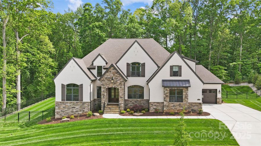 A masterpiece of style and craftsmanship, this custom-built home blends luxury living with effortless entertaining. The primary suite boasts dual walk-in closets and a spa-inspired bath featuring a frameless glass wet-room, waterfall-edge tub, and dual showerheads. Entertain in style with a custom dry bar with built-in shelving and beverage refrigerator. The chef’s kitchen is adorned with custom cabinetry, granite countertops, Monogram appliances, and oversized hidden scullery. Upstairs, enjoy a spacious media and billiards room with a wet bar, as well as the homes 2 additional guest rooms and large bonus room. Pocketing doors reveal a private outdoor retreat with a gas fireplace, remote-controlled screens, and a heated saltwater pool. A 3-bay garage with epoxy flooring adds the perfect finishing touch. Set on .48 acres with a custom retaining wall, this home is surrounded on two sides by wooded common area and offers expansive outdoor living in a private, meticulously crafted setting