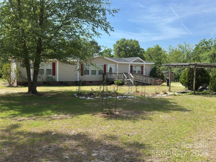 Enjoy peaceful country living with this spacious 3 bedroom 2 full bath manufactured home situated on 3.939 acres of land. This well maintained home offers an open layout featuring a large den area, dining area and functional kitchen with plenty of cabinet space. The master includes a private bath with double vanity, garden tub and separate shower, while the 2 additional bedrooms located on the opposite end of the home, provide flexibility for your family, guests, home office or hobbies. Outside, the expansive acreage provides plenty of room for gardening and outdoor activities with a carport and additional storage buildings. Whether you're looking for a place to expand or a quiet place to call home, this property offers the perfect balance of rural charm and convenience of local amenities.
