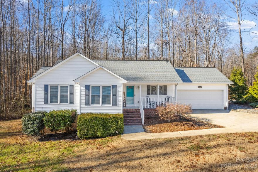 Discover the charm of this 3BR/2BA home in Ironton Acres, set on .95 acres with a backdrop of open lawns and woods. Inside, vaulted ceilings and a gas log fireplace create a welcoming ambiance. The open floor plan includes a spacious kitchen and dining area, perfect for hosting. Step onto the composite deck for a view of the serene backyard, which extends to a tranquil creek. A cozy fire pit promises memorable outdoor moments. The home includes a large crawl space for extra storage, adding practicality to its appeal. A driveway leads to a 2-car garage, complemented by a concrete buffer for additional parking. This 1,377 sq ft property is an ideal sanctuary for homeowners and a smart choice for investors, with no HOA restrictions. Conveniently situated, it's 20 minutes from Denver, NC, and 15 minutes from Lincolnton, offering a peaceful yet connected lifestyle.