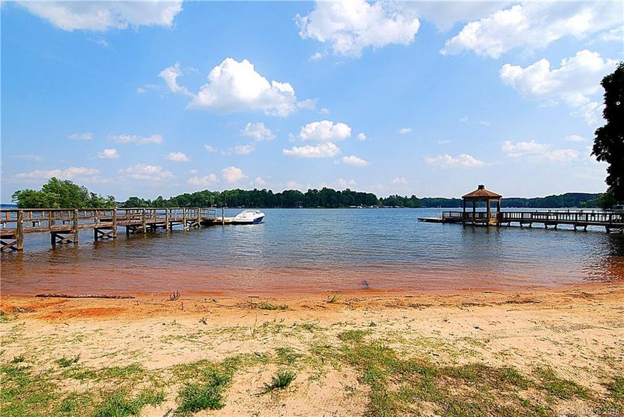With 120+ feet of big water view and a beach this is an amazing Lake Norman waterfront find!  Wide open water views, and a cabin that you can use until you decide to build a dream home. A flat lot, a sandy beach, a boat ramp grandfathered, a pier built recently, and a brand new floating dock await you.  The star here is the lot and these amazing views, the house is in very good condition and could easily be used for a long time without a doubt.
