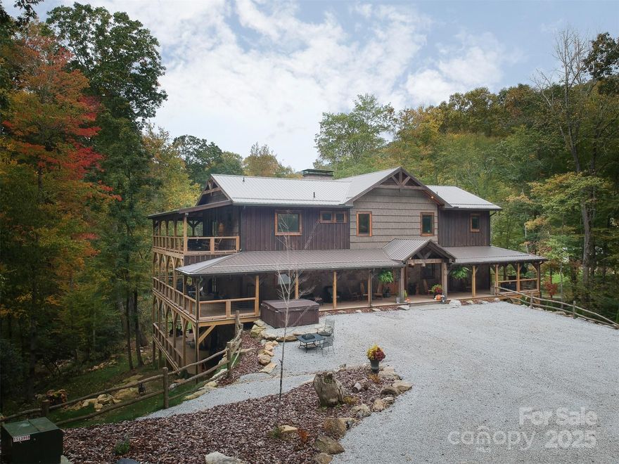 You cross the wooden bridge. Everything is quiet. Hungry and Leabs Creeks thread through and cradle the home. Waterfalls and natural pools hush the day. Inside the 5,611 sq ft Home is built with grit and grounded in history... dry-stack stone pulled from the land, reclaimed antique barn wood, exposed poplar bark, upper floors in ambrosia maple. Cathedral ceilings hold morning light and evening stillness. Hand Forged Lighting bring ambiance to this oasis. Outside, more than 4,000sqft + of covered deck spans three levels.... sip your coffee while water coils below, deer tread soft between the trees and eagles glide overhead. The home sits on +/-10 acres while the two Creeks whisper music from either side of the secluded home. Green House included to grow your herbs and plants. Native Trout swim in hidden pools. Wildlife moves as quietly as you watch  from your rocking chair.  Owner-finance may be available  starting around 4.94. Home is offered including the beautiful furniture so you can move in and quickly enjoy the warm and inviting Home. Peacefully tucked away but convenient to Asheville, Brevard, Waynesville, BRP, Springdale CC, Big East Fork trailhead to the Shining Rock Wilderness and East Fork of the Pigeon River.

This property can be a Heirloom Home along with a lifelong investment to share to the world as a Vacation Home, Wedding or event estate, business retreat or the perfect secluded Home. 
This isn’t just a Hidden Secret or a Home by the creek it’s the ground that can be passed down for generations.