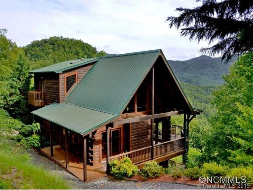 Spectacular log home with an equally spectacular mountain view!  Large great room with cathedral ceilings & gas log fireplace opens onto a wide covered porch allowing you to be one with the outdoors. Enjoy outdoor dining or simply relax & soak up the splendor of the mountains. Master BR on the main level features a stone FP, soaking tub and opens onto the deck. Guests will enjoy their own space on both the 2nd and lower levels.
