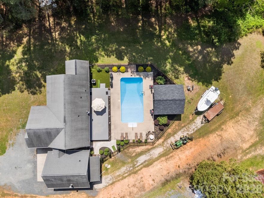 Discover the perfect retreat nestled on 1.25+/- acres in Albemarle, offering space, privacy, and a relaxed lifestyle just minutes from town. This inviting home features an open-concept living area and a thoughtfully designed split-bedroom floor plan that provides both comfort and functionality.

The primary suite offers a peaceful escape with convenient access to the backyard through the laundry room, enhancing everyday flow and functionality. Step outside to enjoy the sparkling pool and unwind under the cabana—perfect for entertaining or cooling off during warm Carolina days.

Recent updates throughout the home enhance both style and convenience. The interior has been freshly painted, with new flooring in the laundry room and updated rugs adding a fresh touch. The kitchen features a new sink, new dishwasher, and a range upgraded from electric to propane for improved cooking performance. Bathrooms have been updated with new toilets and modern fixtures, and an additional bathroom in the garage has been fully finished—ideal for poolside use, allowing guests to enjoy the outdoors without needing to enter the main home.

The detached double garage offers excellent versatility, including a finished room above—perfect for a guest suite, office, or flex space—along with a cozy wood stove for year-round comfort. Outside, a designated pet area with artificial turf provides a low-maintenance solution for everyday convenience.

Located in a peaceful setting just minutes from downtown Albemarle and close to Norwood, this property offers a balance of tranquility and accessibility.

A rare opportunity to own a move-in-ready home with acreage, thoughtful updates, and inviting outdoor living.