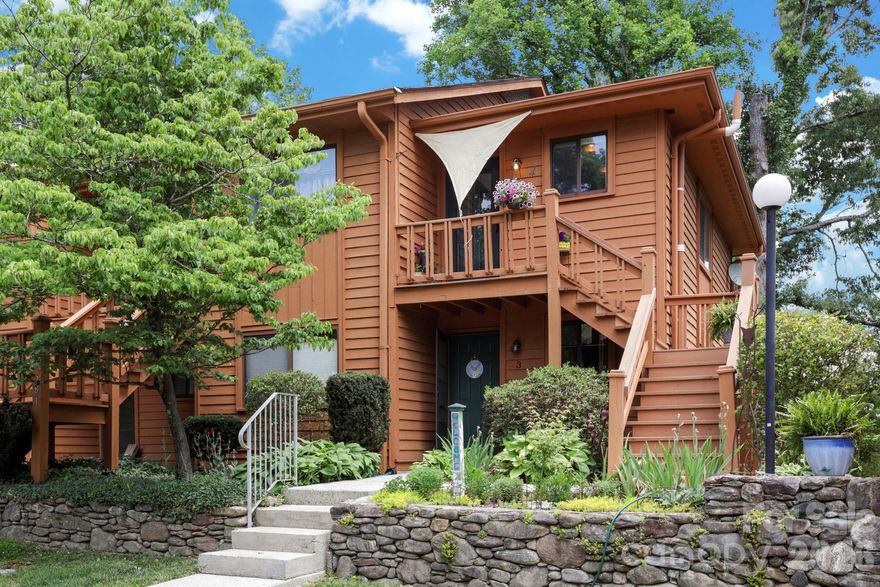 Upper-level 2-bedroom, 1-full-bath, 1-half-bath condo offering the perfect blend of privacy, personality, and low-maintenance living. Positioned at the quiet end of the community — one of the most coveted locations in the development — the home captures distant year-round mountain views from the dining area and overlooks beautifully maintained flower gardens.

Inside, the residence has been thoughtfully updated with bold design choices, including a deep navy accent wall and light engineered-wood-style flooring. Sliding glass doors open from the living area onto a private deck — an ideal spot for morning coffee surrounded by mature tree canopy. The kitchen features white cabinetry and pendant lighting, while the dining area is brightened by a statement chandelier.

Recent mechanical upgrades — new roof, gutters, HVAC, and a water heater, a few years young — provide genuine peace of mind, and HOA dues are paid through December 2026. 

All of this sits just minutes from Downtown Hendersonville, the Ecusta Trail, Historic Flat Rock, Flat Rock Playhouse, the Carl Sandburg Home, Pardee Hospital, and AdventHealth — with Downtown Asheville only 30 minutes away. A rare opportunity to own a distinctive, move-in-ready home with character and convenience in equal measure.