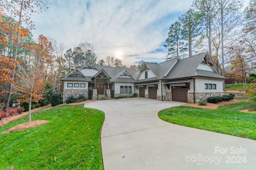 Stunning custom home in a sought-after Lake Norman community is designed to impress with its stone, brick, and Hardi shingle exterior, highlighted by arched wooden gables for timeless curb appeal. Impressive great room with soaring cathedral ceilings, exposed wood beams, and stone fireplace flanked by custom built-ins.Gourmet kitchen features an oversized island, Wolf gas cooktop, pot filler, double ovens, Dolomite countertops, and a walk-in custom pantry.White oak, wide-plank flooring and high-end lighting add to the elegance.Custom designed buffet and china cabinetry adorns the dining area.Luxurious primary suite features two spacious closets, a spa-like bath with soaking tub. Upstairs offers a spacious bedroom suite w/full bath, a bonus room, and ample storage.Outdoor living is exceptional with a covered porch featuring a stone fireplace, reclaimed wood beams, and composite decking. The private backyard is pool-ready. Enjoy neighborhood lakefront amenities and a vibrant social club.