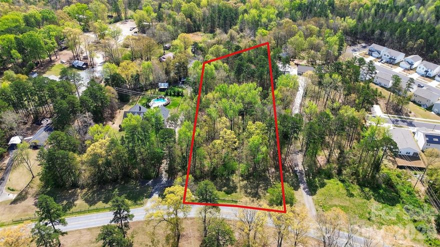 2.32 acres less than 20 minutes to the heart of Uptown! This private property offers a quiet retreat while being minutes from amenities, healthcare and even close to Mountain Island Lake. The property is wooded, creating as much or as little privacy as you desire, with a gentle slope towards the middle, ensuring water will flow away from the presumed homesite towards the back. There is access to water and sewer with tap fees, so no need to worry about well or septic. Come make this the site of your next home!