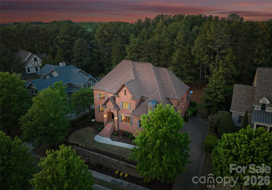 Welcome to 16849 Ashton Oaks Drive—an exceptional custom-built, full-brick two-story estate offering 5 bedrooms, 5 bathrooms, and 5,201 square feet of refined living, nestled within the prestigious gated enclave of Ashton Oaks in The Palisades. This European-inspired residence artfully blends luxury, privacy, and timeless design. The thoughtfully curated main level features eight interconnected living spaces designed for both everyday comfort and elegant entertaining. Highlights include a private guest suite—ideal for multigenerational living or extended stays—a dedicated study perfect for remote work, and a luminous sunroom with dual entry and French doors, creating a peaceful retreat for quiet reflection. A classic formal dining room sets the stage for memorable gatherings, while the main living area is anchored by an elegant gas fireplace framed by custom built-in cabinetry and enhanced by soaring ceilings and abundant natural light. At the heart of the home, the gourmet kitchen is both functional and sophisticated, featuring custom cabinetry, a Thermador 6-burner professional cooktop, and a full suite of premium appliances. An oversized granite island with prep sink serves as a central gathering point, seamlessly connecting to the main living areas and sunlit breakfast space. Outdoor living is equally impressive, with a resort-style covered rear porch—perfect for grilling, entertaining, or simply enjoying the serene, wooded backdrop. The main level is completed by a beautifully appointed laundry room featuring a full cabinet suite, granite countertops, and a stainless steel deep-bowl sink. The upper level serves as a private retreat, accessed by two separate staircases, and offers four spacious bedrooms, three well-appointed bathrooms ( 1 is a Jack-and-Jill bath with double vanity), a secondary home office and a versatile bonus room with custom cabinetry and floor-to-ceiling storage provides exceptional flexibility. The elegant primary suite is a true sanctuary, featuring expansive natural light, a custom tray ceiling, designer lighting, dual walk-in closets, and a distinctive barrel hallway leading to the spa-inspired bath with a seamless tiled shower and Roman soaking tub. Recent updates completed in April 2026 by the sellers include refinished Brazilian cherry hardwood floors on both levels, new Shaw carpeting in the bedrooms, fresh interior paint throughout (including ceilings, walls, trim, and closets), and updated lighting fixtures. The expansive three-car garage has been refreshed with a newly painted interior and a custom epoxy floor. The covered rear porch has also been professionally cleaned and stained, enhancing its natural beauty. Enjoy close proximity to Lake Wylie, scenic walking trails, and the exceptional lifestyle amenities that define The Palisades—one of Charlotte’s premier communities. Ideally situated, once again, the home is just a short walk to The Palisades Country Club, where resort-style amenities include the Jack Nicklaus–designed golf course, driving range, tennis courts, resort-style pool, dining, and a state-of-the-art fitness center. Schedule your private tour today.