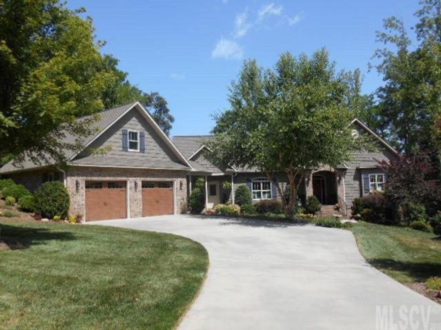 Gorgeous custom home built in 2009 on this beautiful gated, lake front lot with approximately 200 feet of lake front land. Stroll or drive down the path to your private dock and covered boat house. Enjoy the breeze and amazing view from the two back decks and screened in porch. The irrigation system, landscaping and trees provide a private oasis for you to enjoy this beautiful 3 bedrooms and 2 and a half bath home. There is a large rec room and even a second kitchen on the lower level to allow privacy and comfort for you and your guests. The main kitchen has granite counter tops and stainless steel appliances. Maintenance free brick and vinyl shake siding. The striking hardwood floors beautifully contrast the richly cherry stained Knotty Alder cabinets. The large master suite is accented by a tray ceiling and Jacuzzi tub with his and her vanities topped with cultured marble. A stone fireplace with gas logs provides that warm comfort while watching the amazing sunsets and water views. T