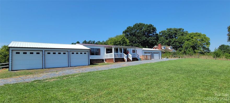 MOUNT GILEAD - Come to the Country !! Inviting 3-bedroom, 2-bath, double wide. Features living room, kitchen, dining area, covered front and back porches. Both showers have been upgraded to tile surrounds. Attached 2-car garage. Detached 3-car garage on 1.29 acres.