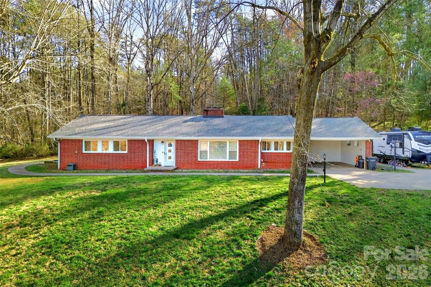 Welcome to a property where "built to last" isn't just a phrase — it's the foundation philosophy. This full brick rancher sits proudly on three parcels totaling 3.47 acres, offering the kind of space that lets you breathe deeply and live freely in the heart of the North Carolina mountains.

Step inside to find three bedrooms and two and a half bathrooms, all conveniently situated on the main level. No stairs required for daily living — though you'll want to explore the full basement below, where half has already been finished and heated, ready for your creative vision. Think recreation room, home gym, studio, or whatever suits your lifestyle.

When it comes to staying comfortable year-round, this home doesn't believe in putting all its eggs in one basket. You'll enjoy heating and cooling through a central system with gas backup, a gas log fireplace for cozy evenings, and a wood-burning fireplace for those who appreciate the authentic crackle and glow.

Outside, a covered back porch invites you to savor mountain mornings with coffee in hand. The property also includes a separate workshop with an attached one-car carport — perfect for projects, hobbies, or extra storage. With the Blue Ridge Parkway just minutes away and convenient grocery shopping nearby, you'll enjoy both seclusion and accessibility.

Properties with this level of quality construction and acreage don't come along often. Schedule your private showing today and see this one in person.
