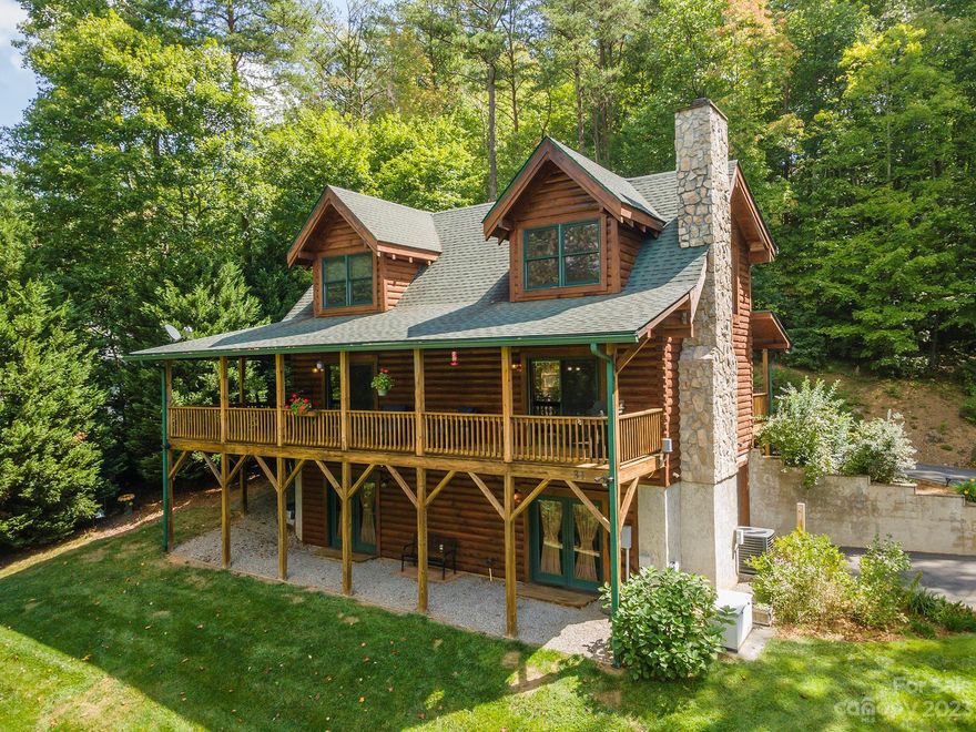 Impressive modern rustic log cabin on private .75 Acre lot in Forest Creek neighborhood in Candler, minutes from Asheville. NO CITY TAXES! 2 BR,2.5 BA  1.5 story LOG CABIN. Family room on lower level w/ WIC and 1/2 bath is currently exercise room. Could be used as a 3RD BR. Primary BR can be on Main or Upper! Designed by Fireside Log Homes with D-Log Style, interior side milled flat and the exterior side curved. Siding washed and stained in August 2023. Cozy and rustic rooms, vaulted ceilings in LR and Main bedroom, modern kitchen with stainless appliances, Corian countertops and breakfast bar. Wood burning 2 story masonry stone fireplace is a beautiful centerpiece in LR. Large loft upstairs provides extra sleep space. T&G Hardwood pine floors, white pine paneling walls adds warmth and character! HOA allows: 6 month min rental and/or downstairs room can be rented once compliant with code ingress/egress. Enjoy the outdoors on huge wrap around covered porch complete with private Hot Tub.