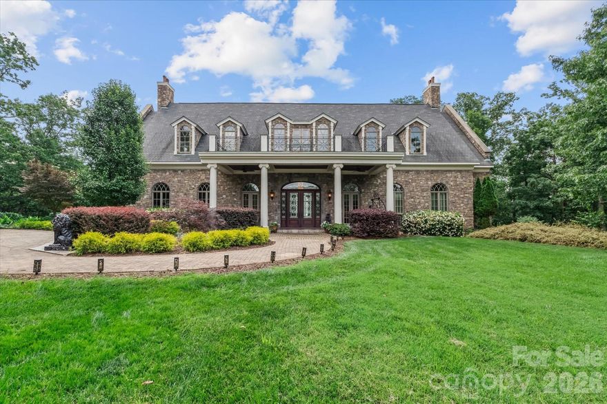 Welcome to 530 Sierra Trace, known as FeatherStone Manor — a private estate where refined craftsmanship meets breathtaking natural beauty. Set on 14.4 acres, this all-stone residence commands sweeping panoramic views of the Yadkin River and the Uwharrie National Forest. Designed for those who appreciate uncompromising quality, the home showcases exquisite architectural detail, including bespoke woodwork and cabinetry, marble baseboards and window sills. The thoughtfully curated interior features a rustic lower-level wine cellar, creating an elegant setting for collectors and entertainers alike. The estate grounds are equally impressive, unfolding across five landscaped tiers. Enjoy evenings by the fire pit, or on the private putting green and sand trap accessible by stairways or a service drive suitable for a golf cart or UTV. Residents of The Springs enjoy lake access to High Rock Lake — with boat launch, slips, clubhouse, swimming pool, hot tub, tennis/pickleball courts.