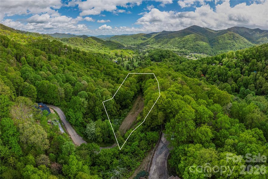 Build your dream mountain home in desirable Big Springs Cove Estates, just above Maggie Valley and adjacent to Maggie Valley Club & Resort. This 1.24-acre homesite offers a cleared building area, excellent privacy, and beautiful long-range mountain views, with underground utilities already in place for easy development.
Situated at the end of a private paved road, the property provides a quiet, tucked-away setting while still being close to area attractions. A minimum 1,700 sq ft site-built home is required, making it an excellent opportunity for a full-time residence or mountain retreat.
Enjoy convenient access to golf, dining, and resort amenities, along with nearby outdoor recreation including the Blue Ridge Parkway, Great Smoky Mountains National Park, Lake Junaluska, and the shops and restaurants of Waynesville.