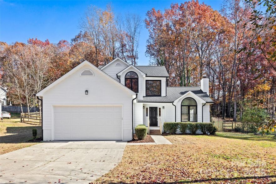 This house is a first-time home buyer's dream come true!  Modern, fresh, and thoughtfully redesigned, this home offers a “new home feeling” with the added benefit of a spacious lot and mature landscaping!  LVP flooring throughout and ceramic tile in the baths mean no carpet anywhere. A vaulted, beamed great room with crown molding, fireplace, and sleek black railings creates a warm, modern welcome. The crisp white kitchen is a standout with quartz counters, stylish backsplash, all-new soft-close cabinetry with under-cabinet lighting, and new Samsung stainless appliances—the dream kitchen you’ve been waiting for. The main-floor luxury primary suite features two closets, a spectacular tiled walk-in shower, soft-close cabinetry, and chic gold accents. Upstairs bedrooms and the secondary bath are beautifully updated and move-in ready. Fresh white exterior paint with black accents, a new roof, updated garage door, and epoxy-coated garage floor add even more appeal. Step outside to a freshly painted deck overlooking the best part: a newly seeded and strawed backyard, fully fenced with brand-new gates—ideal for pets, play, gardening, and outdoor living. Convenient to Birkdale Village, shopping, dining, hospitals, and easy access to I-77. All this move-in ready, beautifully modernized, and truly exceptional with no HOA. Come discover it today!