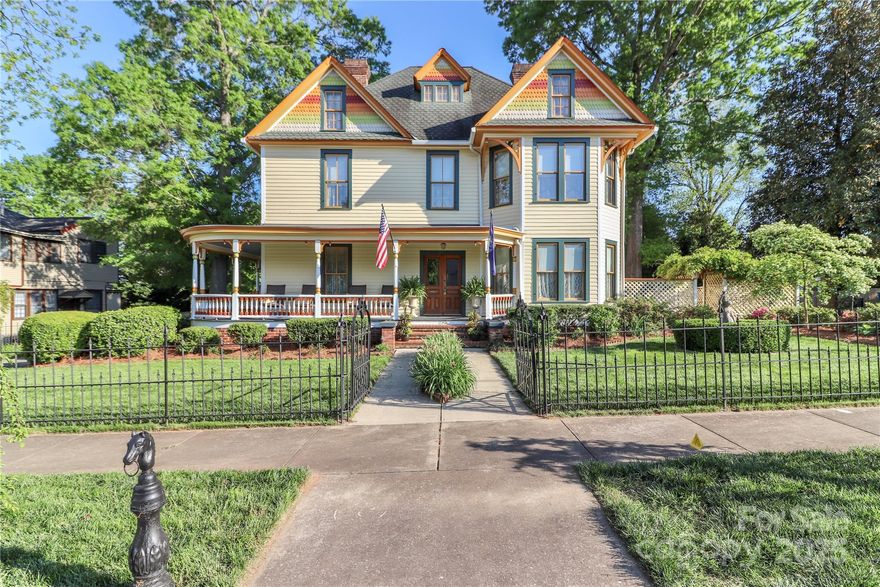 Historic Victorian with Modern Comfort! This beautifully preserved late-1800s home blends timeless character with thoughtful updates. Enjoy the wraparound front and side porches, classic wrought iron fencing, and inviting curb appeal. Inside, the grand foyer opens to a formal parlor with a fireplace and ornate tin valances, along with a cozy living room featuring beadboard walls and a second fireplace. The showstopping original staircase and pine flooring add historic warmth throughout. The elegant dining room flows into a chef’s dream kitchen with a stamped tin ceiling, granite countertops, double ovens, gas cooktop, prep sink, and built-in Sub-Zero refrigerator. Upstairs, the spacious primary suite includes a separate sitting room, plus three additional bedrooms and a convenient laundry area. The third floor offers flexible space ideal for storage, crafts, or a home studio. A deck off the kitchen leads to a screened-in atrium accented with stained glass. The detached garage includes a heated room, full bath, and private entrance—perfect for a guest suite, studio, or second living quarters. Recently encapsulated crawl space, updated furnace register to update intake, New exhaust fan in kitchen, Additional lot property listed MLS 4353919.