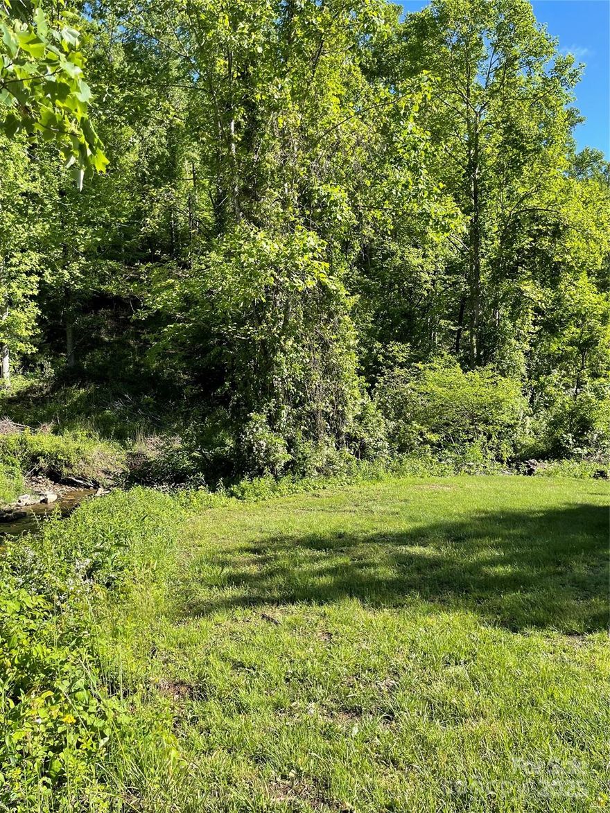 6.1 Acre lot with a serene stream gracing the front, offering a picturesque setting. The gently sloping terrain toward the rear provides versatile opportunities for building, landscaping, or recreation. Ideal for those seeking a peaceful retreat with natural beauty and ample space.l