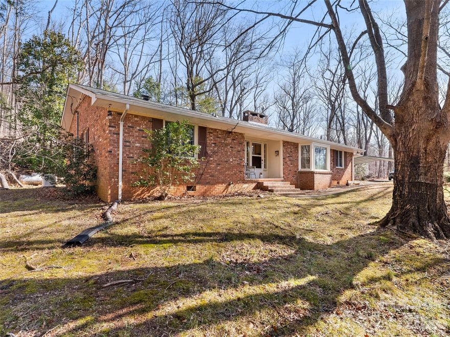 Tucked between Columbus and Tryon, this classic brick home offers privacy, space, and incredible potential in a peaceful wooded setting. Conveniently located with easy access to Interstate 26, Hendersonville, and Spartanburg, you will enjoy both seclusion and connectivity.
Set on a beautifully wooded lot filled with wildlife, the home features a spacious living room with a large bay window overlooking the trees and direct access to a screened porch that is perfect for morning coffee and bird watching. The double sided fireplace warms both the living room and the separate dining room, creating a welcoming heart of the home.
The kitchen is well appointed with quartz countertops, a cooktop, and a double oven. A functional mud room just off the garage includes a sink, toilet, washer, dryer, and built ins for everyday convenience.
Three bedrooms are located off a central hallway. One bedroom features built in bookshelves, while the primary suite offers three closets and a private bath.
Per seller, the roof was replaced in 2022 and the HVAC in 2020. A whole house Generac generator, leaf guard gutters, attached garage, attached carport, and floored attic space add lasting value and peace of mind.
The full unfinished basement provides endless possibilities for storage, workshop space, or future expansion. With no home owners association and solid bones throughout, this home is ideal for a buyer ready to update and make it their own.
Waiting for your vision, this property offers the perfect foundation for your next chapter.