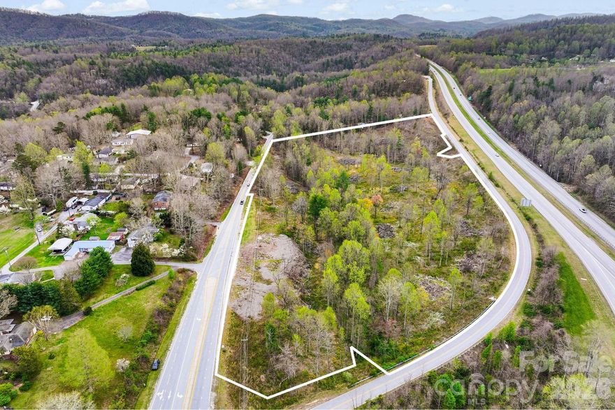 Positioned in one of Henderson County’s most dynamic commercial growth corridors, this ±18.38-acre offering presents a rare opportunity for large-scale development just off the Hwy 25 / Spartanburg Highway interchange. With approximately 1,500 feet of road frontage across Spartanburg Highway and 1,800 feet on Laurel Acres Lane, the property offers exceptional visibility, access, and flexibility for a wide range of commercial uses.

Zoned Community Commercial (CC), the site supports an extensive variety of potential uses including retail, service-oriented businesses, hospitality, office, automotive, industrial, and mixed-use development. Its strategic location places it directly in the path of continued growth between Hendersonville and the rapidly expanding Upward Road / I-26 corridor, making it highly attractive for both owner-users and developers seeking scale and exposure.

The property features gently rolling topography that is well-suited for thoughtful site planning, with multiple access points and strong frontage enabling flexible layout configurations, phased development, or multi-tenant concepts. A natural creek traverses a portion of the land, offering both character and opportunities for creative site design, buffering, or amenity integration, while still leaving substantial usable acreage for development.

Surrounded by a mix of established commercial uses, light industrial activity, and residential growth, this location benefits from strong traffic patterns and proximity to major transportation routes. The combination of scale, zoning, road frontage, and location is increasingly difficult to find in today’s market, particularly within such close proximity to I-26 and key regional connectors.

Whether envisioned as a retail center, mixed-use project, industrial flex campus, hospitality site, or long-term land hold, this property offers a compelling foundation for a high-impact commercial development in one of Western North Carolina’s most sought-after submarkets.