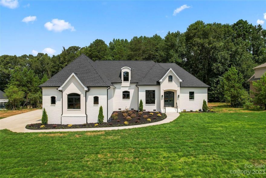 Welcome to the stunning 2023 custom built home in the gated Farrington community! Backing to trees, this fully brick beauty sits on .75 acres w/ gorgeous landscaping & a 3-car garage. This home has a RARE floorplan that includes the primary suite AND secondary suite w/ separate living qaurters all on the main floor. Every inch of this home boasts elegance, w/ marble bathrooms, detailed tile flooring, designer fixtures, custom closets & a large sliding glass door in the living room! The open concept kitchen includes quartz counters, large island, SS appliances & beautiful soft gold finishes. Relax in the living room w/ the cozy fireplace & wooded views. The primary bedroom boasts a soaking tub, full marble shower that matches the vanity & spacious custom closet. Head to the secondary primary suite that includes an attached kitchenette & living area that leads directly to the back patio. Head upstairs to find a HUGE bonus room and 2 add'l bedrooms that share a jack and jill bathroom.