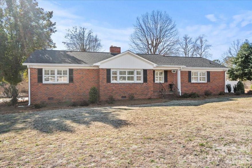 The interior of this brick ranch located on a 1.54 ACRE corner lot was extensively updated in 2022 and is ready for a new owner! It is within walking distance of Pageland's downtown area amenities and features updated kitchen with island and SS appliances. The adjoining breakfast area is a pleasant spot to enjoy your morning coffee. The split bedroom plan affords plenty of privacy for the primary bedroom/sitting area and oversized en suite bathroom.  The living room has a cozy fireplace with gas logs that adjoins the dining room. Both areas feature the beautiful original hard wood floors. There is a rear covered deck for your outdoor enjoyment and a double carport with breezeway access to the rear entry.
