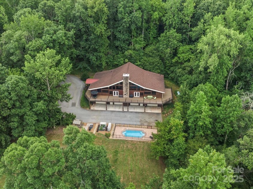 Welcome to 257 Flintlock Drive—a peaceful oasis designed for everyday enjoyment. Watch wildlife from the kitchen table through oversized windows, or unwind by the saltwater pool and backyard firepit with built-in seating. The wraparound composite deck overlooks apple and pear trees, a thriving garden, and berry bushes. Inside, the modern kitchen features double ovens, a pot filler, and instant boiling water faucet. Large walk-in closets with built-ins, a slate shower and clawfoot tub in the primary suite, and a wood-burning fireplace offer luxury and comfort. Car enthusiasts will love the 3,000+ sqft garage with a lift, built-ins, and bathroom for pool days. Full walk-in loft storage. Updated HVAC and 2023 furnace with heat pump and propane backup. This home is filled with thoughtful upgrades and serene spaces—bringing you home to where beauty meets function.