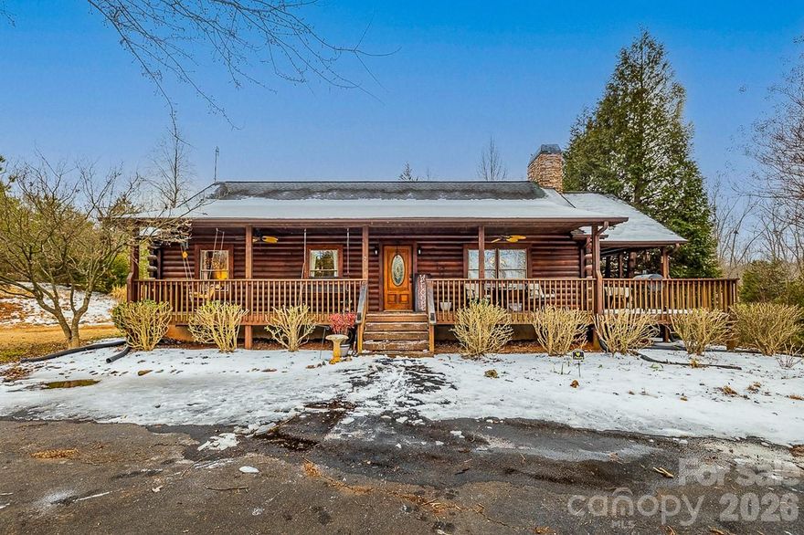 Tucked into a peaceful Rutherfordton setting, 1944 River Crest Parkway presents a beautifully crafted log cabin that blends rustic character with refined comfort. This three-bedroom, two-bath residence welcomes you with a classic wraparound front porch—an ideal spot for morning coffee or evening sunsets—accentuated by warm, thoughtful lighting that enhances the home’s inviting presence.

Inside, the cabin exudes a cozy, relaxed atmosphere with natural wood textures and a thoughtfully designed layout for easy living, anchored by a gas log fireplace in the living area that creates a warm and inviting focal point. The home sits on a generous two-acre lot, providing space to breathe, roam, and create your own outdoor retreat. A circular driveway adds both convenience and curb appeal, while an outbuilding with electricity expands possibilities for storage, hobbies, or a workshop. There are two water heaters and Spectrum is currently being installed for the subdivision.

With its serene surroundings, distinctive log construction, and balance of comfort and function, this home captures the essence of country living while remaining perfectly positioned for everyday enjoyment.